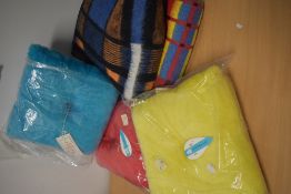 Three 1960s Courtelle pile cushions, as new in packaging and two bright 1960s blankets.