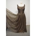 A 1950s Jean Allen taupe coloured evening gown with a slight gold sheen, having full sheer top layer