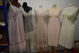 Five 1950s and 1960s sheer and semi sheer nylon slips, all having lace, medium to large sizes.