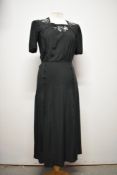 A 1940s day dress having piping to bodice and white beadwork, side metal zip and single button to