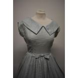 A pale blue 1950s day dress with metallic silver thread running througout, having back metal zip,