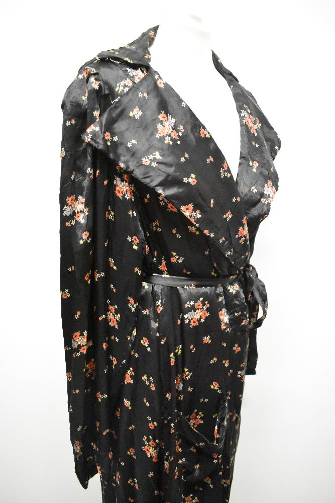 A late 1930s/1940s glossy black rayon house coat, having bright floral sprigs, pocket and dramatic - Image 7 of 7