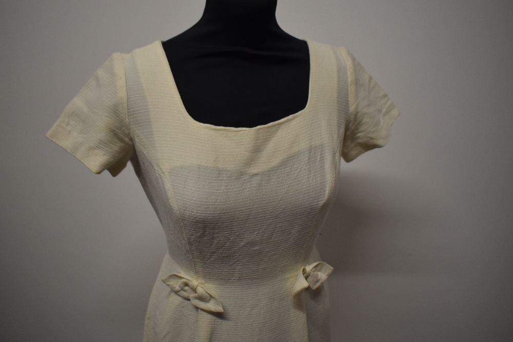 A late 1950s cream textured wiggle dress (wool blend or similar) having scoop neckline bows to hip - Image 3 of 8