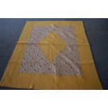 A 1930s/40s 'The Comfy' quilt, having paisley diamond to centre with block yellow surround and