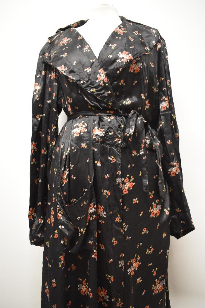 A late 1930s/1940s glossy black rayon house coat, having bright floral sprigs, pocket and dramatic - Image 5 of 7