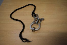 An early 20th century 'Sunrise' stainless steel skirt lifter on lanyard.