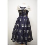 A late 1950s/ early 1960s Susan small dress in navy blue, having machine embroidered floral pattern,