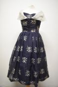 A late 1950s/ early 1960s Susan small dress in navy blue, having machine embroidered floral pattern,