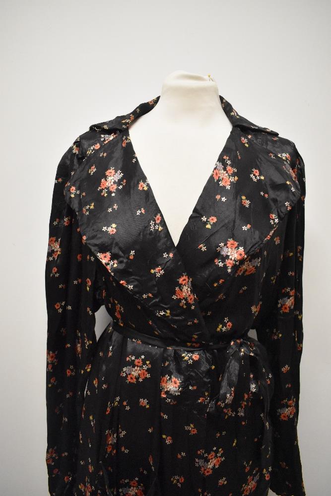 A late 1930s/1940s glossy black rayon house coat, having bright floral sprigs, pocket and dramatic - Image 3 of 7