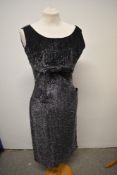 A late 1950s black evening dress with metallic thread detailing, rear metal zip, bow to under bust