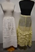 Two antique petticoats, including yellow lawn cotton ruffled example.