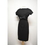 A simple, yet highly effective 1950s black wool wiggle dress, with satin bow to front which