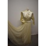 A Late 1940s/early 1950s wedding dress, having 3/4 length bat wing sleeves with buttons, faux wrap