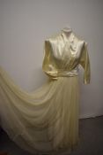 A Late 1940s/early 1950s wedding dress, having 3/4 length bat wing sleeves with buttons, faux wrap