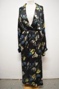 A 1940s glossy black rayon house coat, having vibrant floral pattern, very satin like to the touch.
