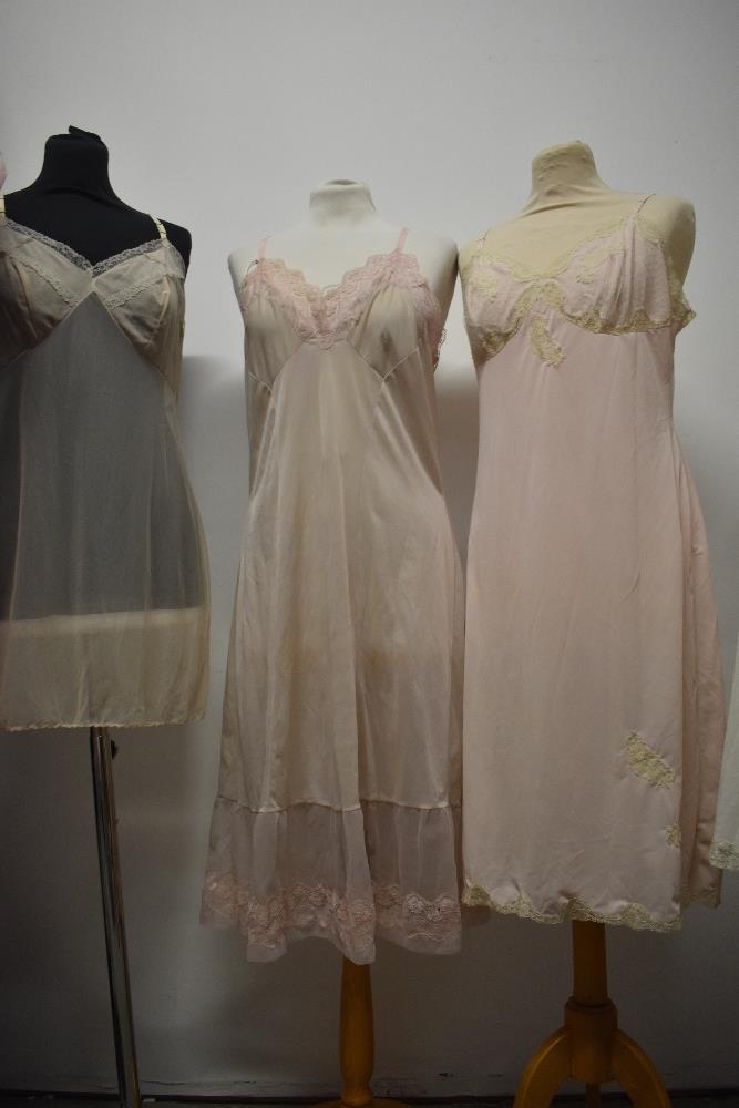 Five 1950s and 1960s sheer and semi sheer nylon slips, all having lace, medium to large sizes. - Image 10 of 12