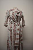 A 1950s crisp cotton floral house coat, with 3/4 sleeves with turn up cuffs, wide tie belt to