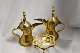 Two brass lidded Dallah coffee pots and a trivet