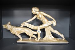 A 20th Century Art Deco chalk ware ornament of a nude female in drapery chasing after a dog, 32cm