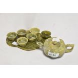 A Chinese carved and varigated green stone miniature tea set, comprising pumpkin shaped teapot,
