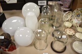 A collection of vintage glass light shades and chimneys.