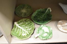A small group of naturalistically moulded cabbage leaf design items, plates, dish and sauce tureen