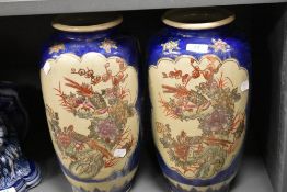 A pair of Japanese cobalt blue crackle glazed vases, decorated with vignettes of floral sprays,