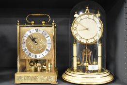 A Kundo German perpetual motion mantel clock, housed under a glass dome, measuring 32cm tall,