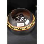 An African clay bowl, with hand painted decoration on black ground and three beaded necklaces and