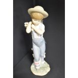 A Lladro boy figurine Flowers On The Back no.1286. Designed in 1974 retired in 1998. 9 inches x 3.