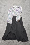 A 1940s dress, having paisley patterned bodice and black skirt, long sleeves and button details to