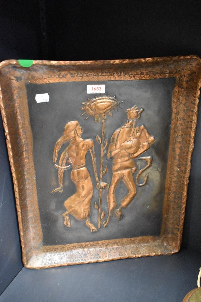 An embossed and etched copper wall plaque, depicting traditionally attired figures to centre.