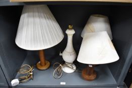 Three wooden lamps with shades, one made from a vintage bobbin along with a marble lamp base.