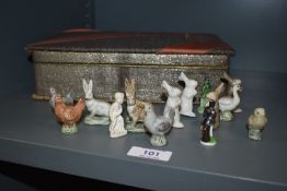 A 1930s chocolate box containing a selection of 1860s porcelain Christmas cracker animals, including