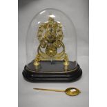 A late 19th Century brass single fusee skeleton clock timepiece, displayed under a glass dome,