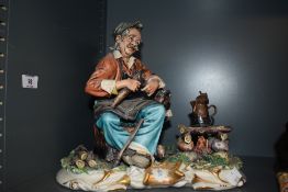 A Capodimonte figure, depicting man whittling wood by camp fire.