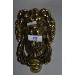 A 19th/20th Century cast metal door knocker in the form of a lion's head, measuring 18cm