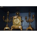 A late 19th Century French brass clock and garniture set, the clock with a two train movement,