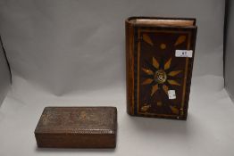 An early 20th Century book form marquetry inlaid box and an intricately carved armorial box with