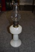 A vintage milk glass oil lamp with chimney.