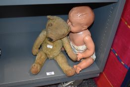 A well loved vintage sawdust filled teddy bear and a mid century doll