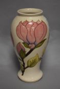 A Moorcroft pottery pink Magnolia pattern vase, marked to the base, and measuring 33cm tall