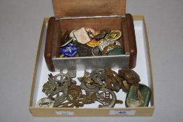 An assorted collection of military cap badges and other badges, including RAF and ATS badges