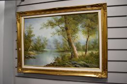 A vintage framed oil on canvas depicting lake and woodland scene, indistinctly signed.