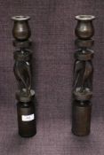 Two turned African hard wood candlesticks, having carved elephants to centres.