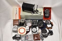 A box of various light meters and focus bellows etc