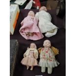 Four early 20th century Dolls, Bisque headed with sleep blue eyes and closed mouth, cloth body,