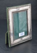 A white metal mounted photograph frame, of rectangular form with reed and ribbon moulded border,