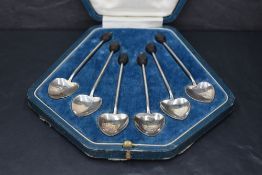 A cased set of six George V silver coffee bean spoons, each with unusual heart-shaped bowls and