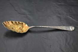 A George III silver berry spoon, the fluted and fruit-embossed pointed oval bowl with gilt interior,